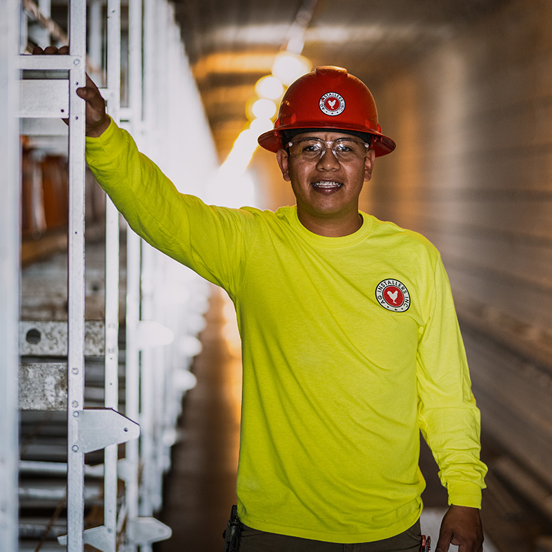 AG Installers employee standing at an installation sight, looking at the camera